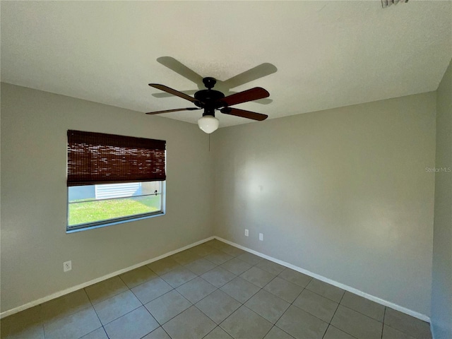 empty room featuring tile patterned floors and ceiling fan