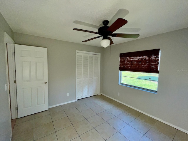 unfurnished bedroom featuring a closet, ceiling fan, and light tile patterned flooring