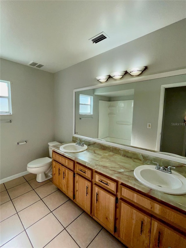 bathroom with vanity, a wealth of natural light, tile patterned floors, and toilet