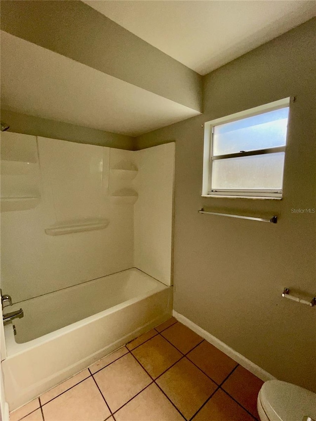 bathroom featuring shower / washtub combination, toilet, and tile patterned flooring