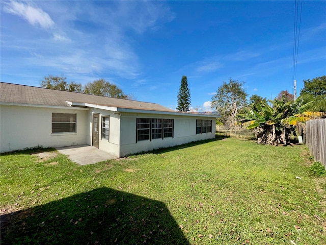 rear view of house with a patio and a yard