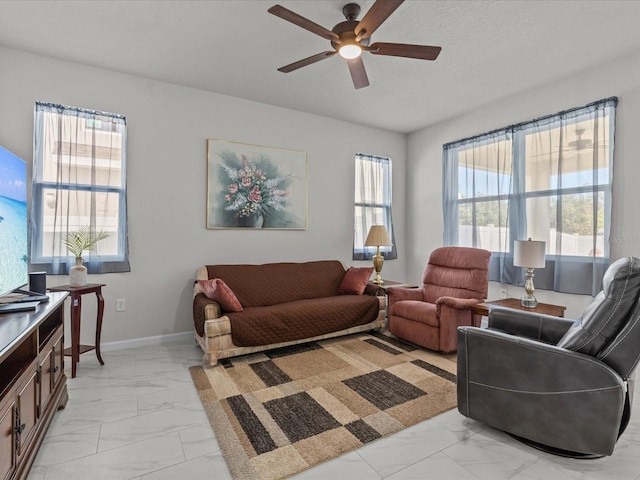 living room with ceiling fan, a textured ceiling, and a wealth of natural light