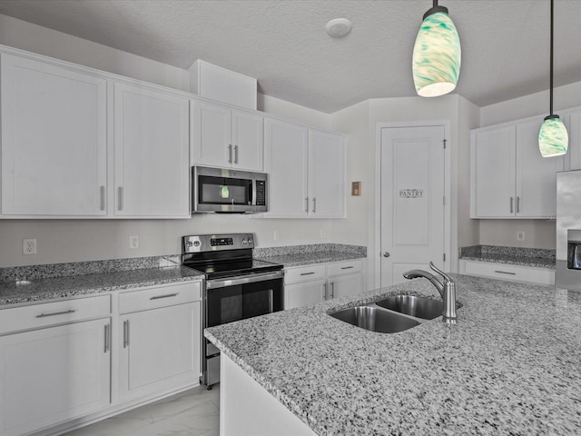 kitchen featuring sink, appliances with stainless steel finishes, hanging light fixtures, a textured ceiling, and white cabinets