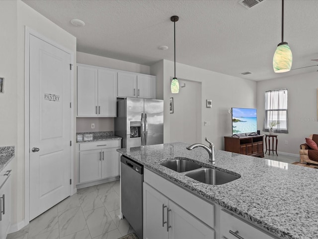 kitchen featuring white cabinetry, sink, pendant lighting, and stainless steel appliances