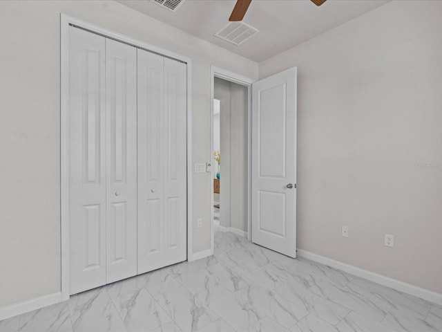 unfurnished bedroom with ceiling fan and a closet