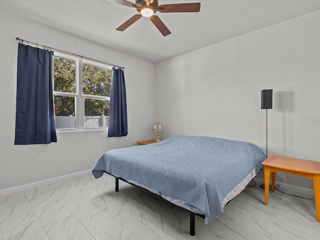 bedroom featuring ceiling fan and a textured ceiling