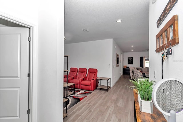 hallway featuring a textured ceiling and light hardwood / wood-style floors