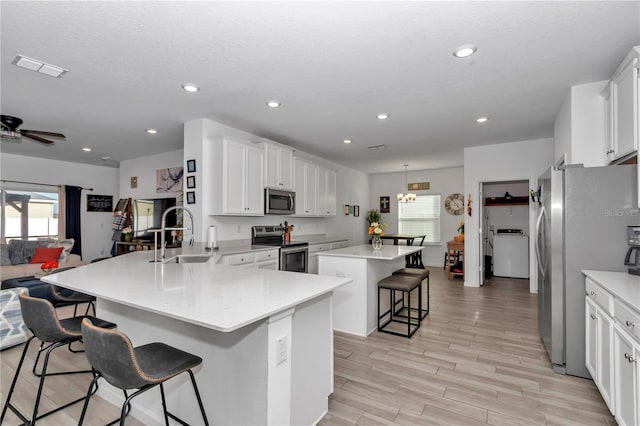 kitchen featuring sink, a breakfast bar area, stainless steel appliances, a kitchen island, and kitchen peninsula