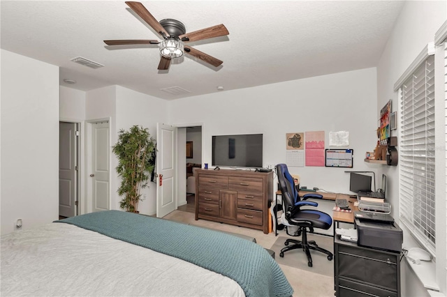 carpeted bedroom with a textured ceiling and ceiling fan