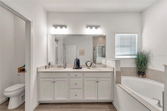 full bathroom featuring vanity, shower with separate bathtub, and toilet