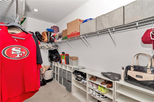 walk in closet featuring light colored carpet