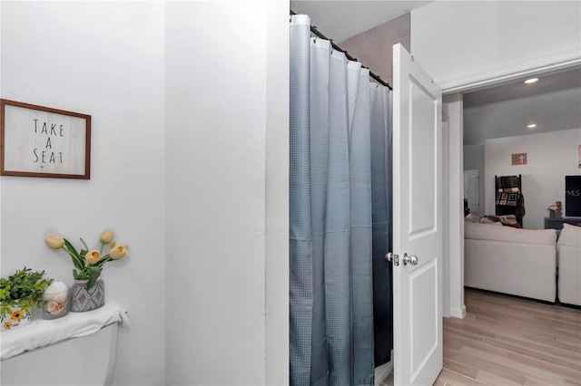 bathroom featuring wood-type flooring and walk in shower