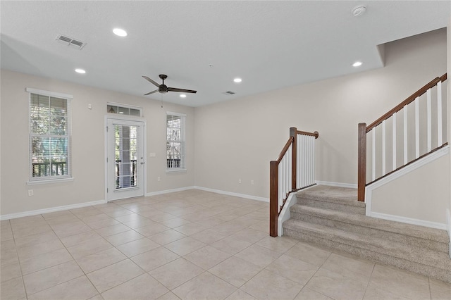 tiled spare room with a textured ceiling and ceiling fan