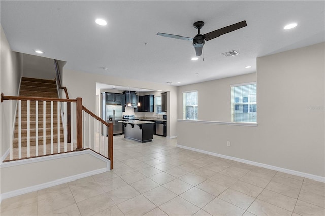 tiled spare room featuring ceiling fan