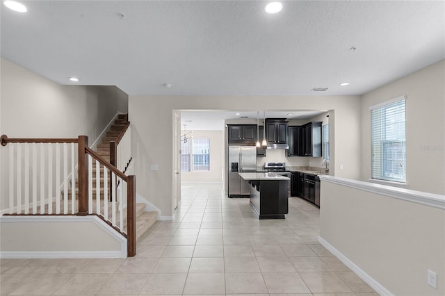 kitchen with sink, stainless steel appliances, a center island, and a healthy amount of sunlight