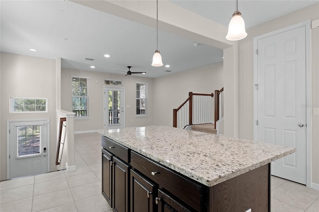 kitchen featuring dark brown cabinetry, hanging light fixtures, and a center island