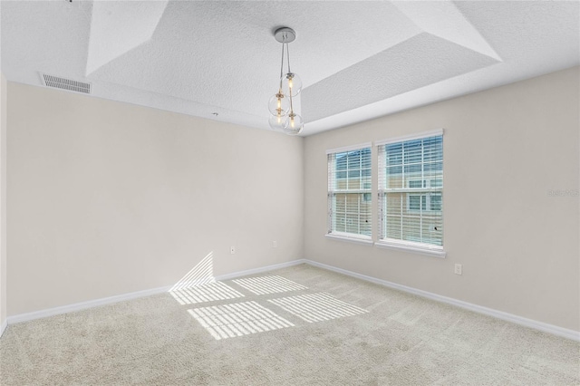 unfurnished room featuring an inviting chandelier, light carpet, and a textured ceiling