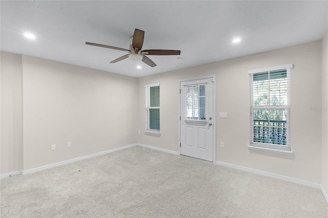 spare room featuring ceiling fan and light colored carpet