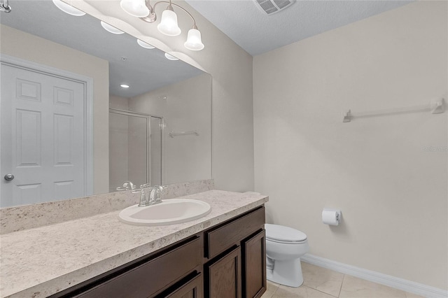 bathroom with a shower with door, vanity, tile patterned flooring, and toilet