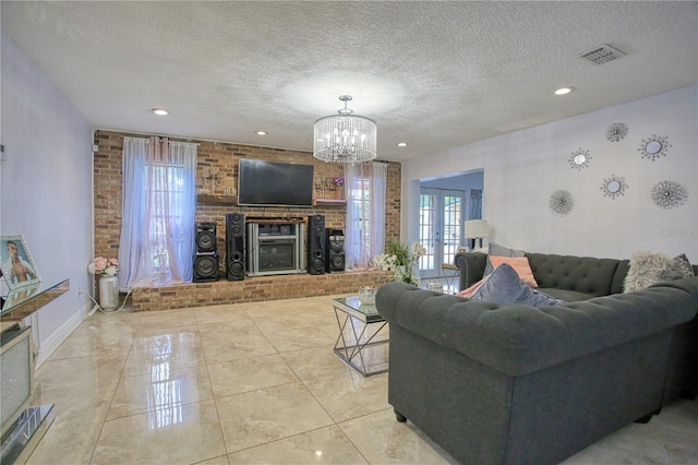 living room with an inviting chandelier, a brick fireplace, french doors, and a textured ceiling