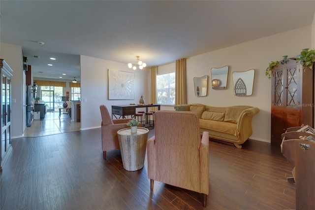 living room with dark hardwood / wood-style flooring, plenty of natural light, and a chandelier