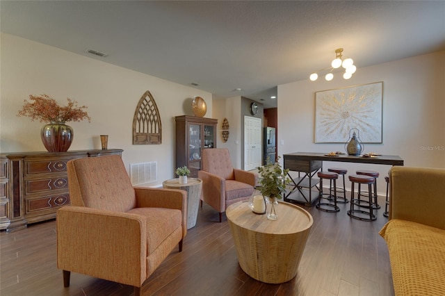 living room with an inviting chandelier and dark hardwood / wood-style flooring