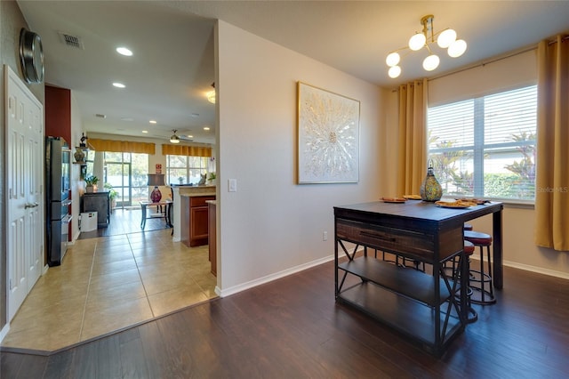 dining room with wood-type flooring and ceiling fan with notable chandelier