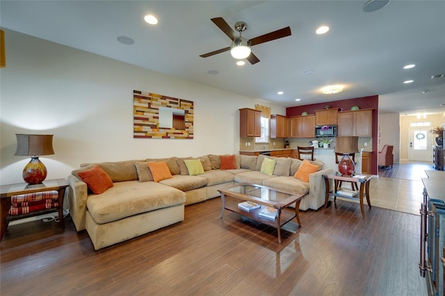 living room with dark wood-type flooring and ceiling fan