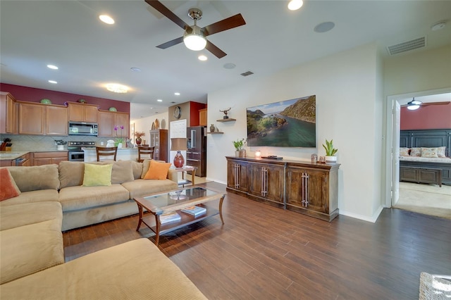 living room featuring dark wood-type flooring and ceiling fan