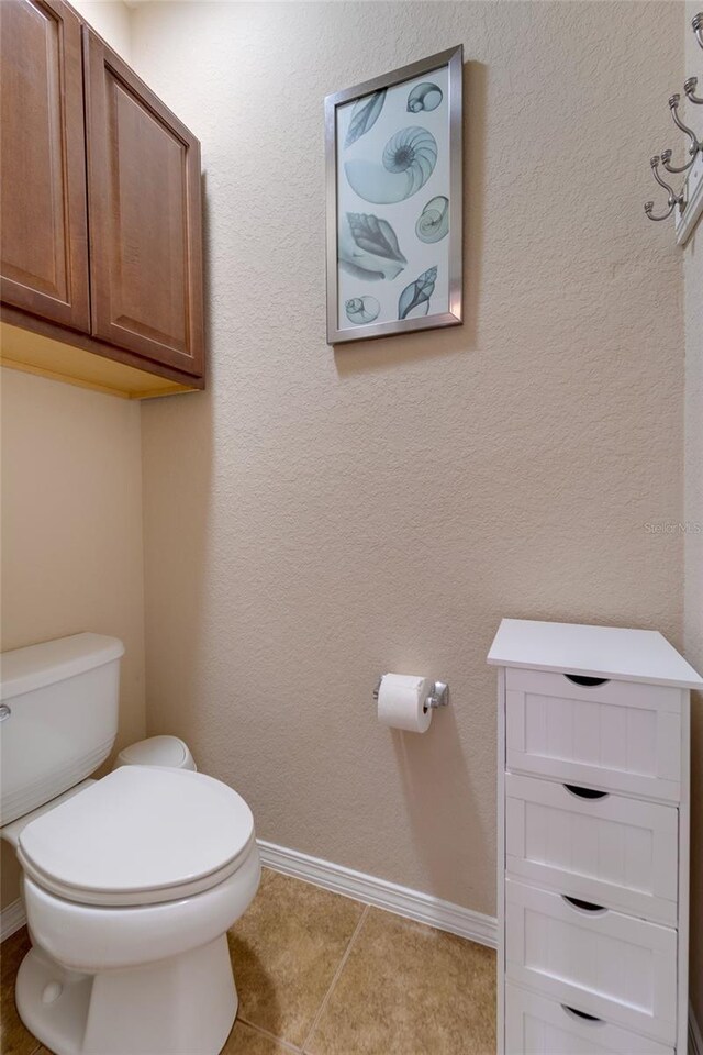 bathroom featuring toilet and tile patterned flooring