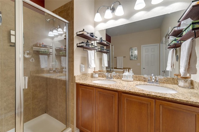 bathroom featuring a shower with door and vanity