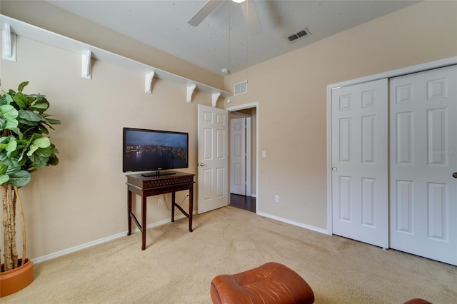 living area with light carpet and ceiling fan