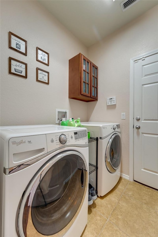 washroom featuring washer and clothes dryer and light tile patterned flooring