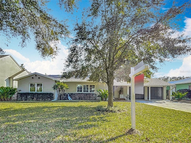 single story home with a garage and a front lawn