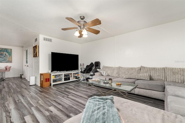 living room with ceiling fan, wood-type flooring, and a textured ceiling