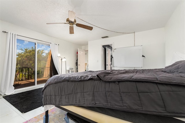 bedroom featuring light tile patterned flooring, ceiling fan, access to exterior, and a textured ceiling