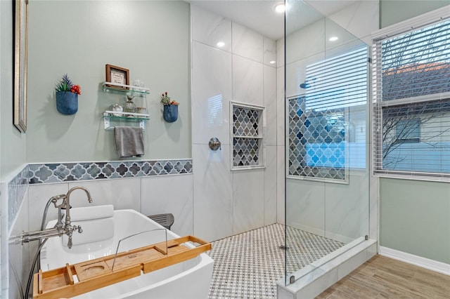 bathroom with shower with separate bathtub, wood-type flooring, and tile walls