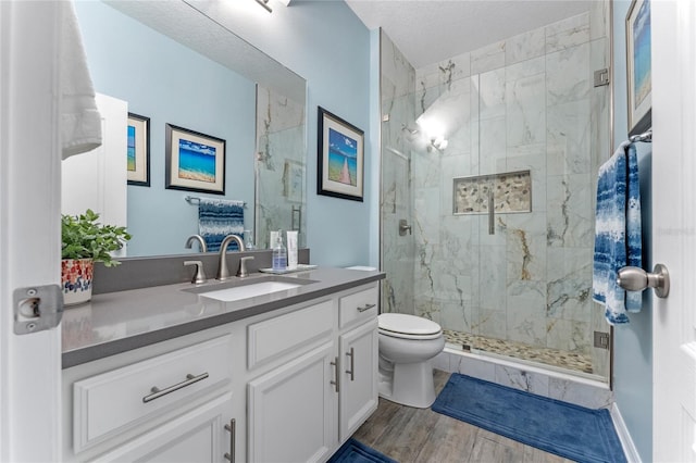 bathroom with vanity, hardwood / wood-style floors, toilet, and walk in shower