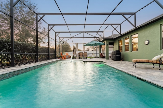 view of pool with grilling area, a patio, and glass enclosure