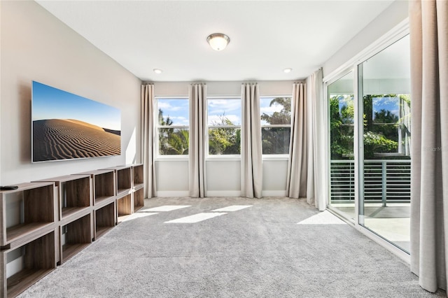 unfurnished living room with carpet floors and a healthy amount of sunlight