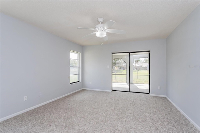 carpeted spare room with ceiling fan and a textured ceiling