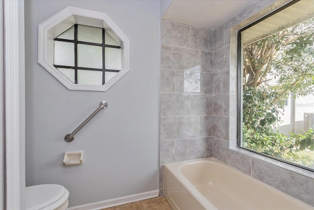 bathroom featuring a tub and toilet