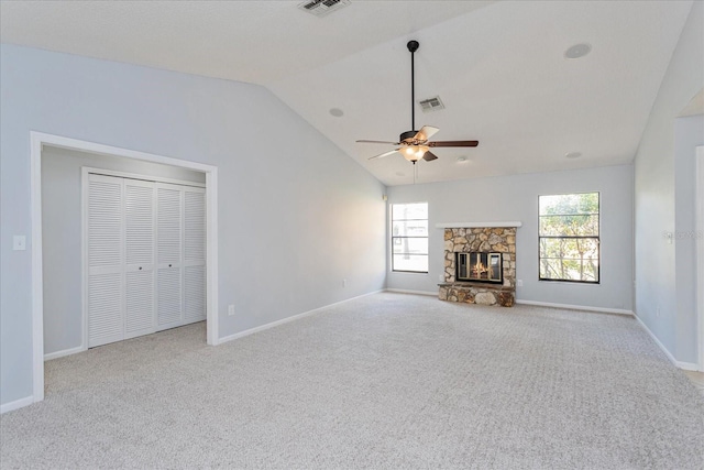 unfurnished living room with vaulted ceiling, light carpet, ceiling fan, and a fireplace