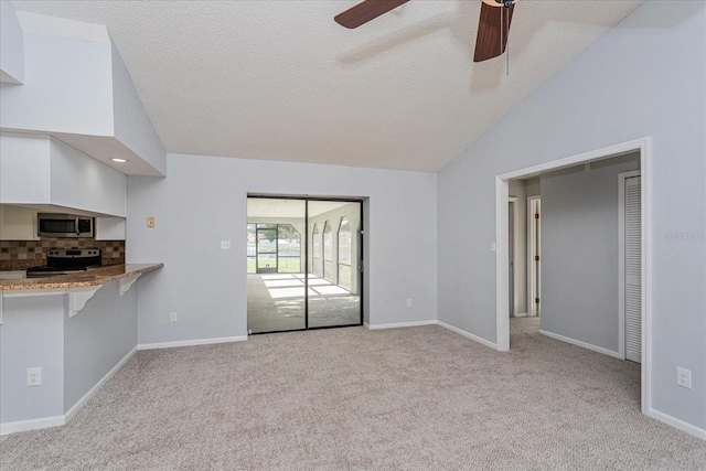 unfurnished living room with a textured ceiling, vaulted ceiling, light colored carpet, and ceiling fan