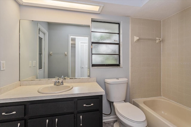 full bathroom featuring tiled shower / bath combo, vanity, and toilet