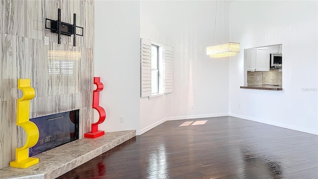 interior space featuring a fireplace, wood finished floors, and baseboards