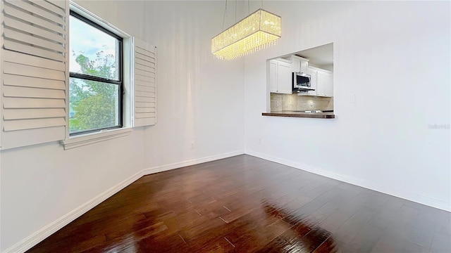 unfurnished room featuring dark wood-style floors and baseboards