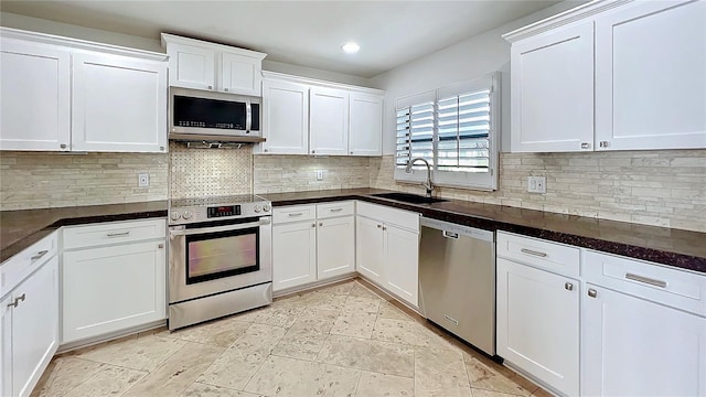 kitchen featuring appliances with stainless steel finishes, backsplash, a sink, and white cabinets