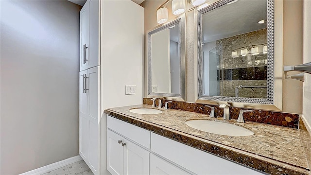 bathroom featuring baseboards, double vanity, a sink, and a shower stall