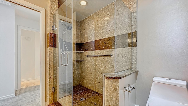 bathroom with a shower stall and toilet